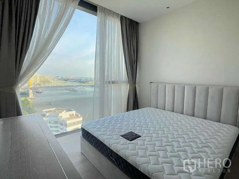 Condominium for rent or sale in Bangkok - Cozy bedroom with large window and river view.