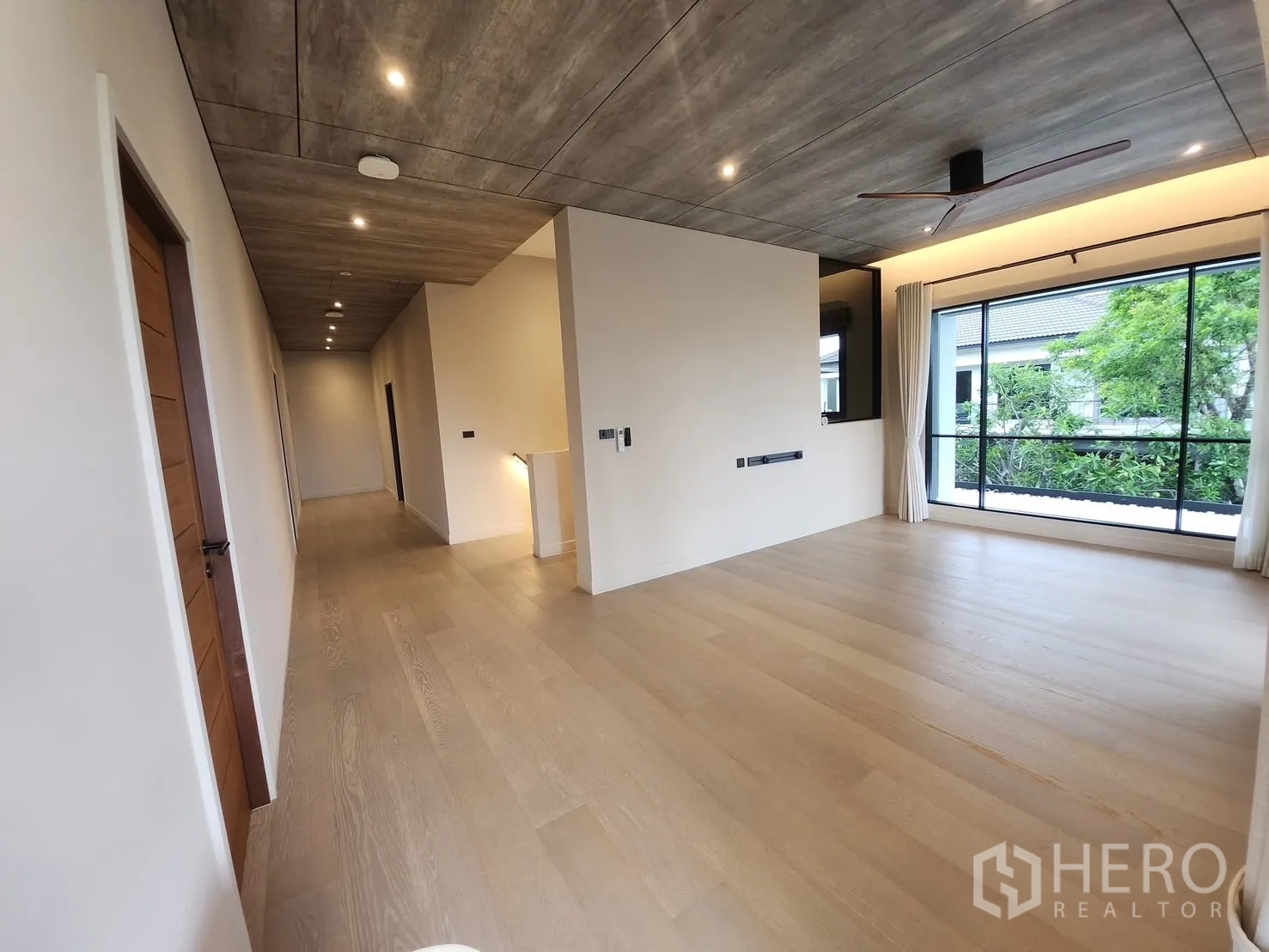 Detached House for rent in Bang Phli, Samut Prakan - Upper hallway and lounge with warm wood flooring and recessed lighting.