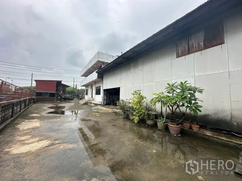 Home Office for sale in Phra Pradaeng, Samut Prakan - Open courtyard beside the warehouse with rows of potted plants.