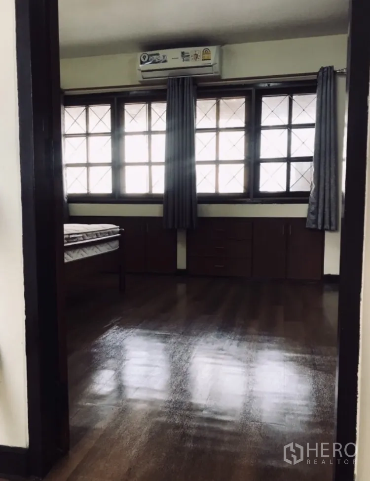 联排别墅 出租在Watthana, Bangkok - 楼上卧室，大格窗户、窗帘、内置柜与木地板