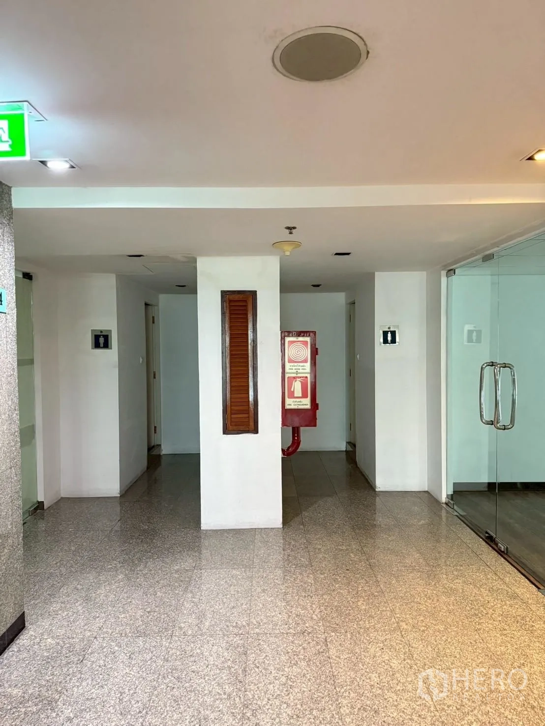 ออฟฟิศ for rent in Watthana, Bangkok - โถงทางเดินอาคารพื้นหินแกรนิต ตู้สายฉีดน้ำดับเพลิง และประตูกระจกเข้าสำนักงาน