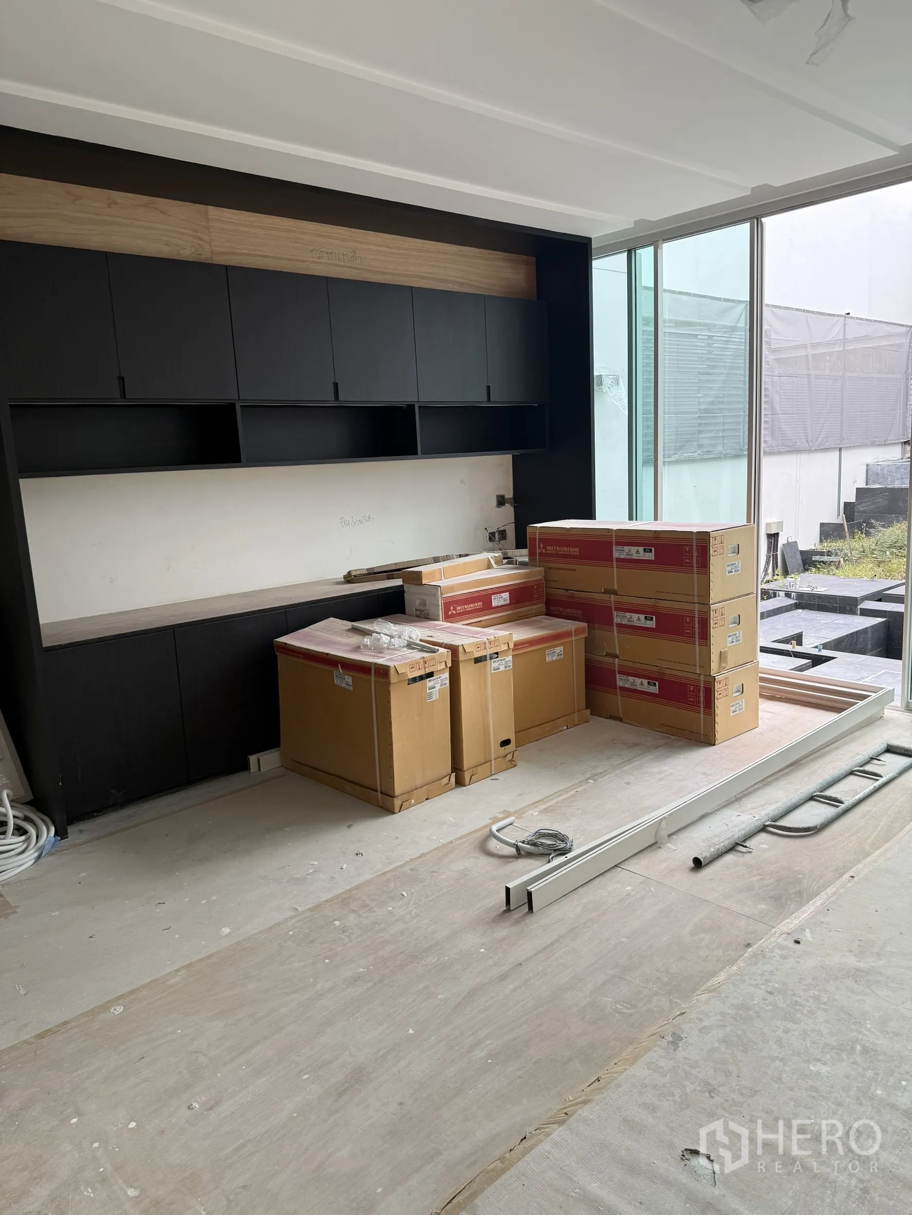 Detached House for sale in Bang Phli, Samut Prakan - Built-in black cabinetry wall facing garden with boxes of appliances.