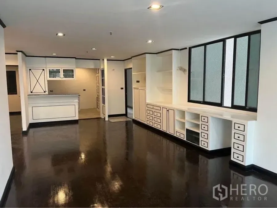 คอนโด ให้เช่าหรือขายในWatthana, Bangkok - โซนนั่งเล่น–ทานอาหารเปิดโล่ง พร้อมผนังบิลต์อินยาวและมุมมองไปครัว