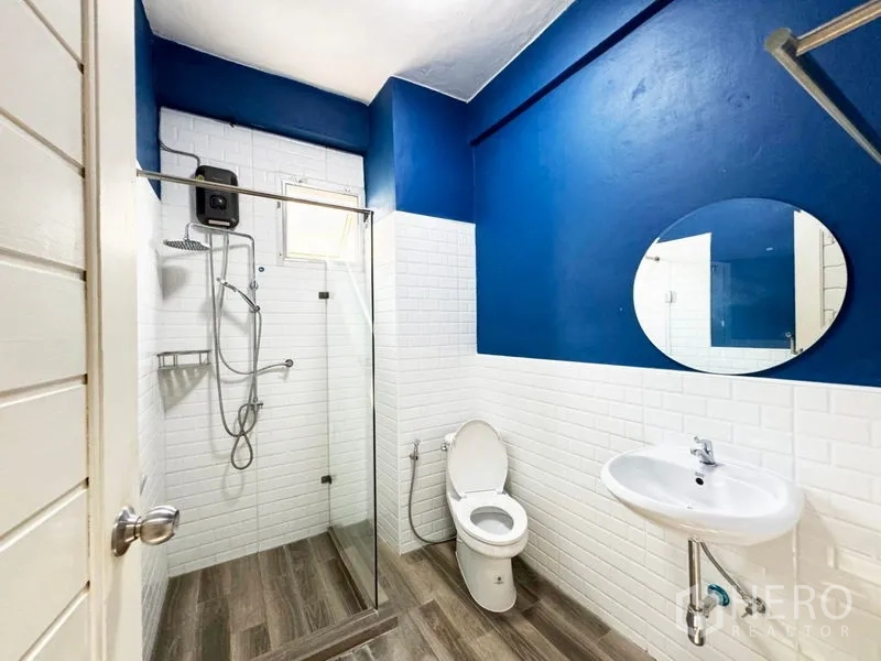 ทาวน์เฮาส์ ให้เช่าหรือขายในSuan Luang, Bangkok - ห้องน้ำผนังสีน้ำเงินกระเบื้องอิฐสีขาวและตู้กระจกกั้นอาบน้ำ