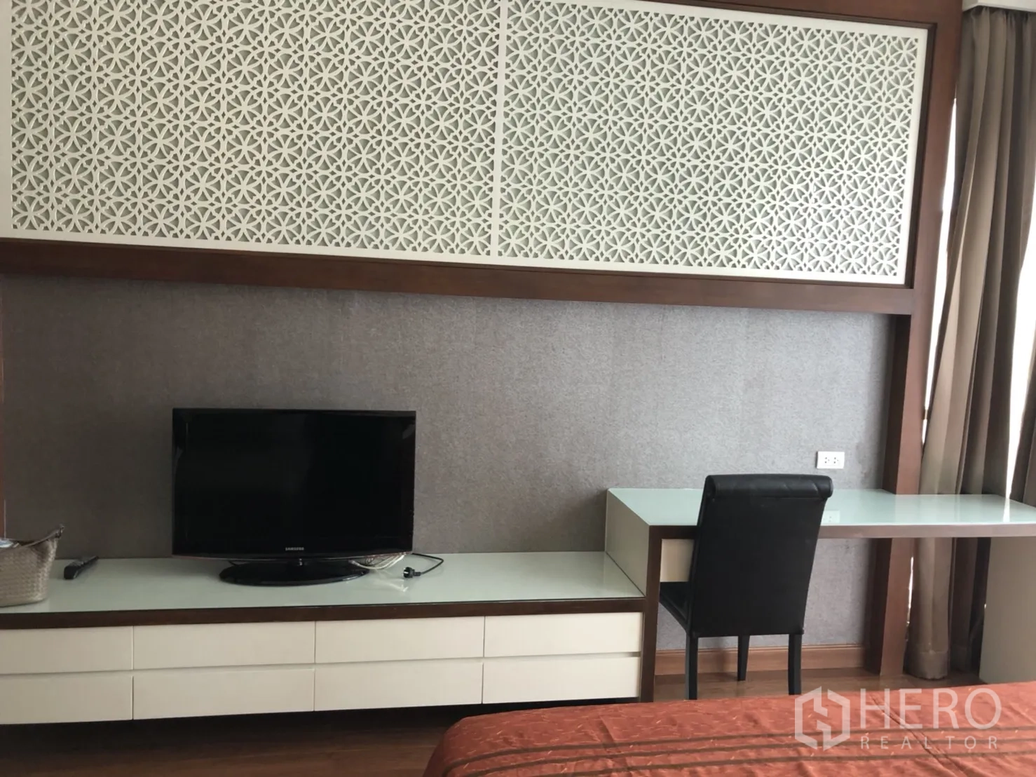 公寓 出租在Pathum Wan, Bangkok - 卧室一角，内置书桌、电视柜与装饰性镂空面板。