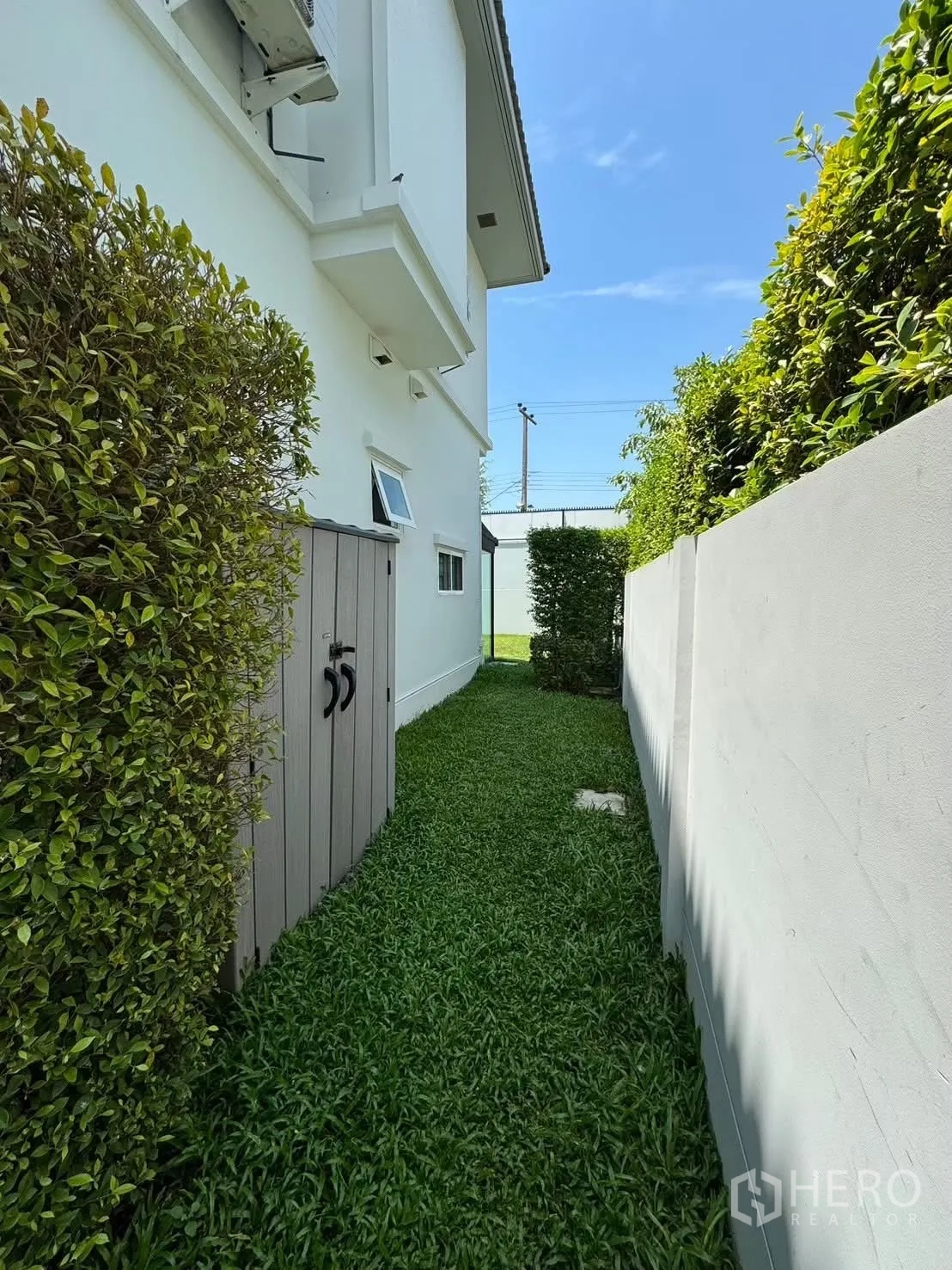 独栋房屋 for rent in Prawet, Bangkok - 侧院步道两侧为高绿篱并设户外收纳柜。