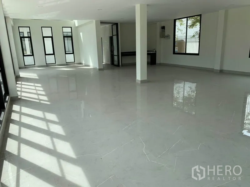 Warehouse for rent in Bang Phli, Samut Prakan - Bright ground-floor office interior with polished tile flooring, support columns, and large windows.