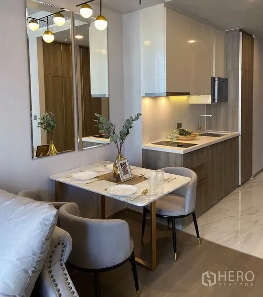 คอนโด ให้เช่าในWatthana, Bangkok - ครัวขนาดกะทัดรัดสไตล์โมเดิร์น เคาน์เตอร์หิน ตู้บิลท์อิน และโต๊ะอาหารสองที่นั่งข้างผนังกระจกเงา