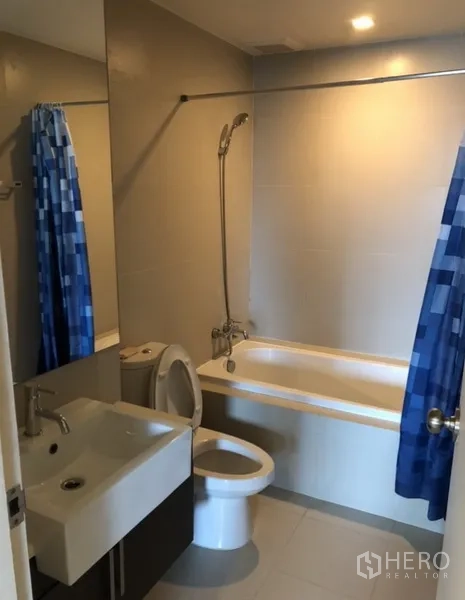 คอนโด ให้เช่าในKhlong Toei, Bangkok - ห้องน้ำพร้อมอ่างอาบน้ำ ฝักบัว อ่างล้างหน้า และม่านอาบน้ำสีน้ำเงิน