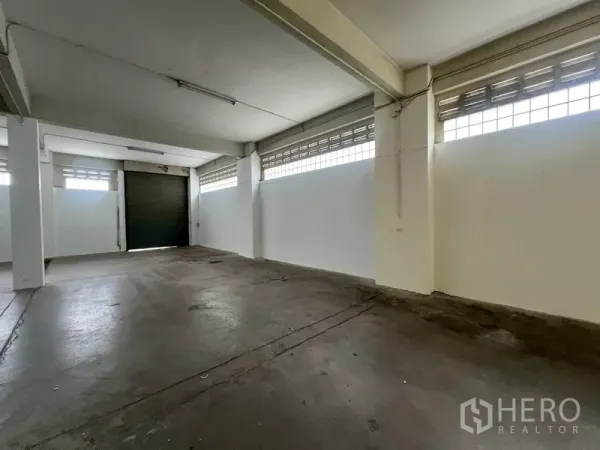 Warehouse for rent in Phra Khanong, Bangkok - Open-plan storage hall with columns, glass-block windows and smooth concrete floor