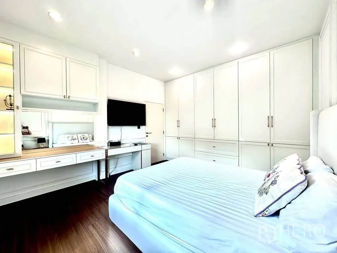 Detached House for rent in Bang Kapi, Bangkok - Bedroom with wall-mounted TV, desk and extensive closets.