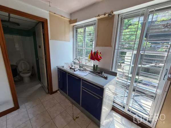 店屋 出租或出售在Sathon, Bangkok - 带水槽的小茶水间，旁边是卫生间与装有栅格的高窗。