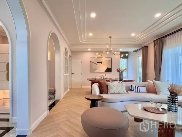 Detached House for rent in Bang Phli, Samut Prakan - Living area with arched doorways, wood floors and a modern chandelier.
