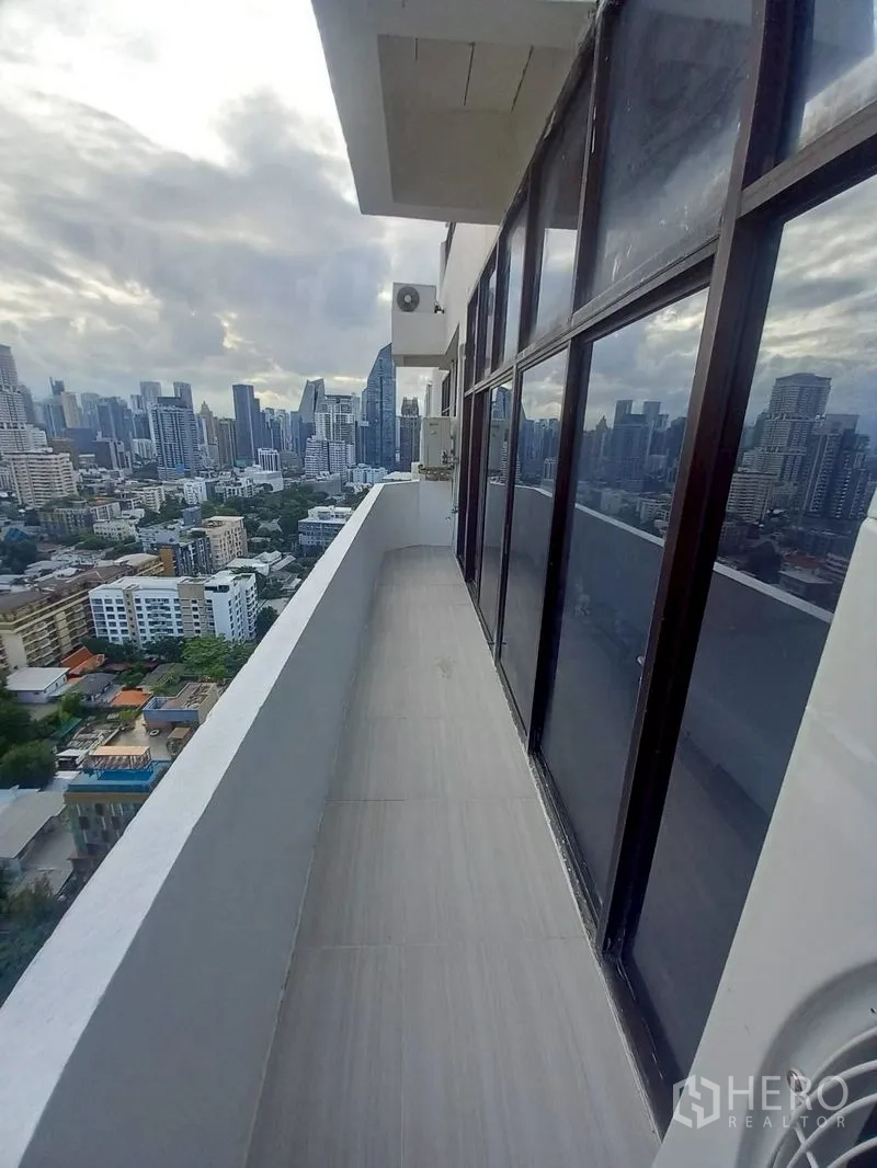 Condominium for rent in Watthana, Bangkok - City view from the balcony overlooking high-rise buildings.