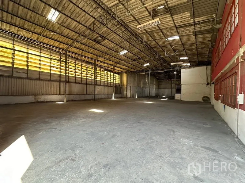 Warehouse for rent in Suan Luang, Bangkok - Large storage bay with high roof and yellow translucent side panels bringing natural light.