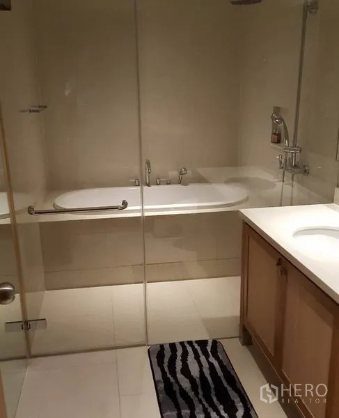 คอนโด ให้เช่าหรือขายในKhlong Toei, Bangkok - ห้องน้ำมีผนังกระจก อ่างอาบน้ำ และเคาน์เตอร์อ่างล้างหน้า