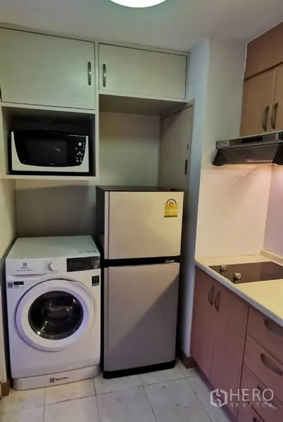Condominium for rent in Watthana, Bangkok - Separate kitchen with washing machine, microwave, fridge, and cooktop.