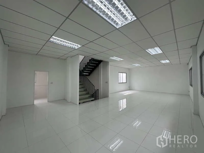 Factory for rent in Khlong Luang, Pathum Thani - Bright tiled office space with suspended ceiling and steel staircase.