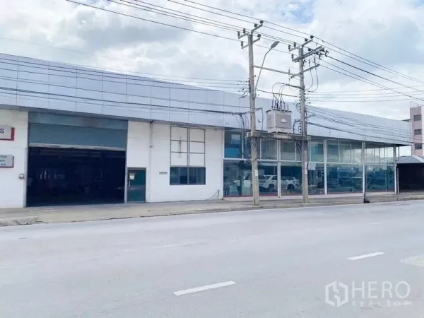 货栈 出租在Bang Khen, Bangkok - 工业建筑的宽阔临街面，大幅展示窗与装卸卷闸通道。