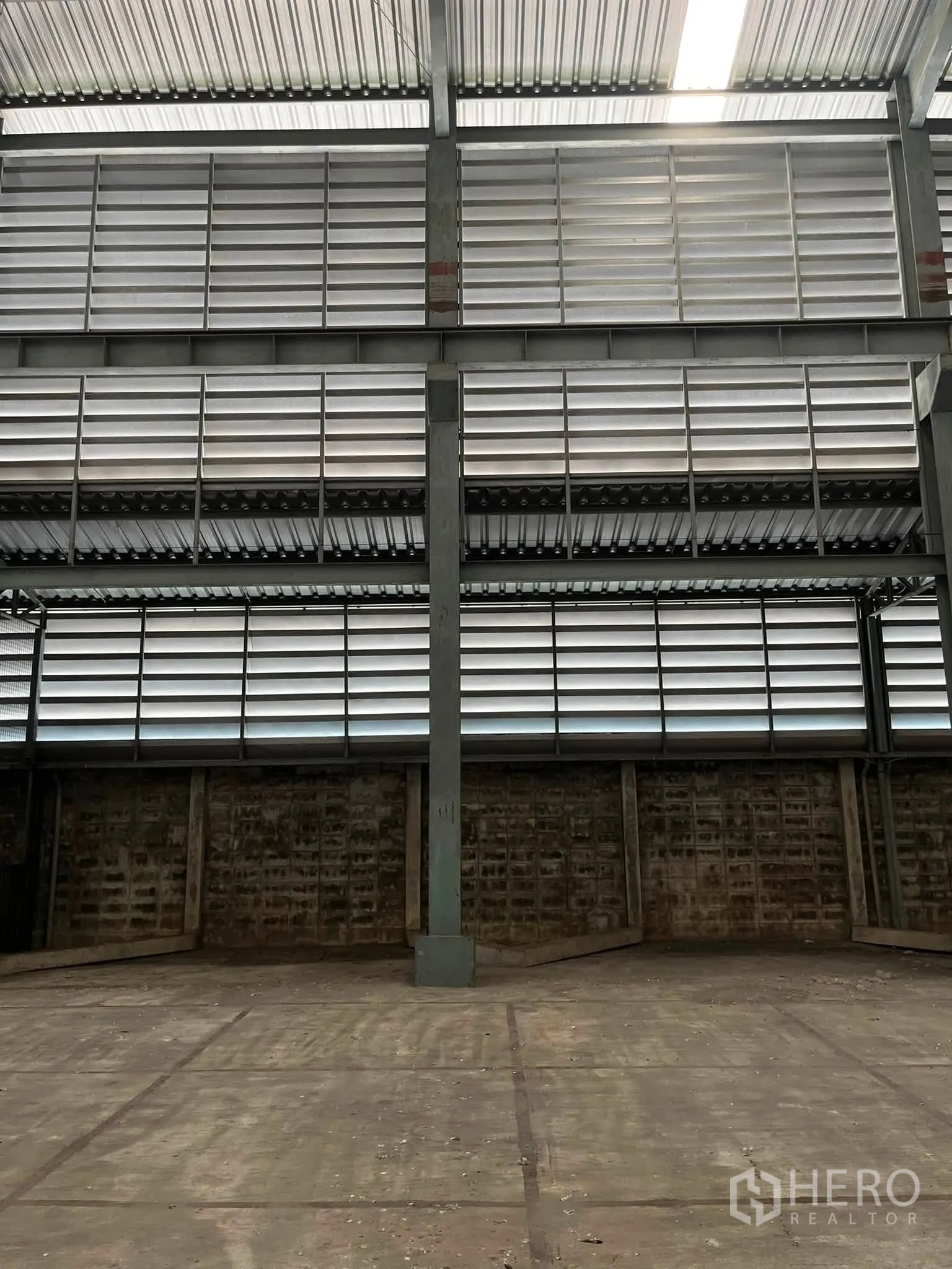 Warehouse for rent in Bang Phli, Samut Prakan - Close-up of steel columns and louvered sidewall ventilation inside the warehouse.