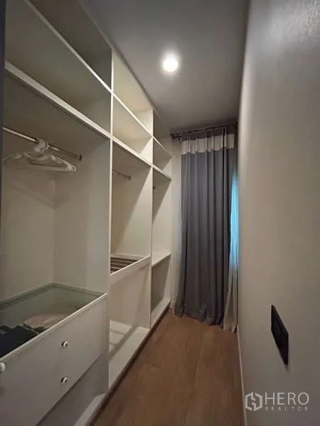 独立式住宅 出租在Bang Kapi, Bangkok - 小型步入式衣帽间，白色搁架与挂衣空间。