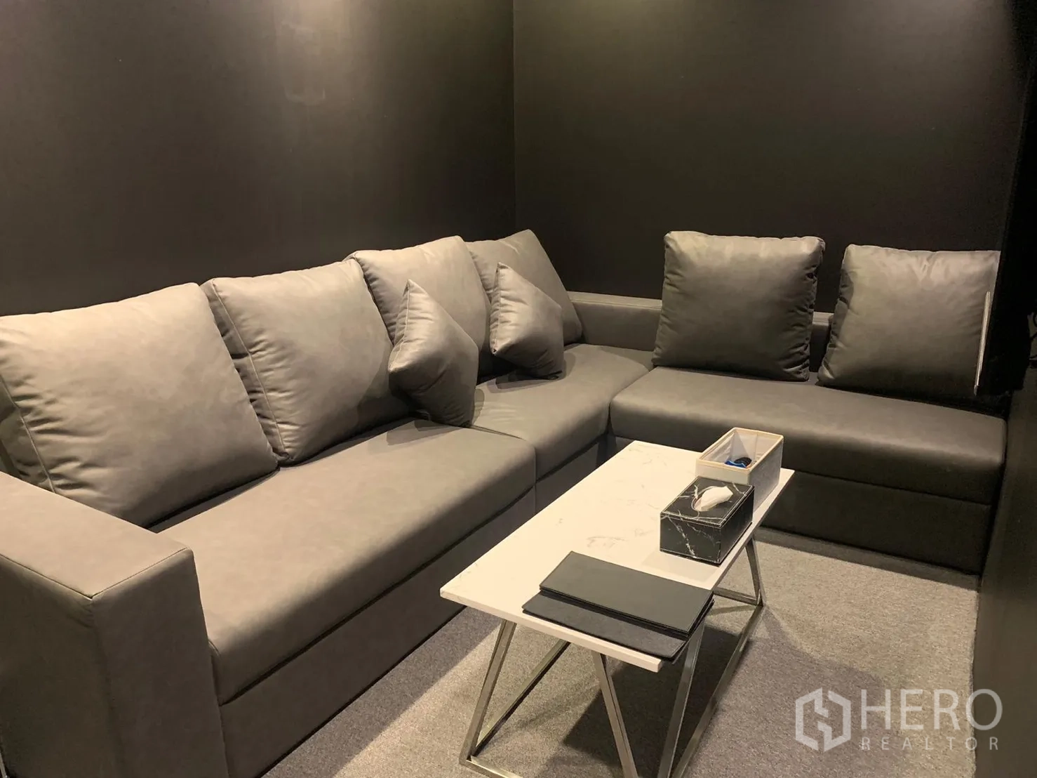 อาคารพาณิชย์ ให้เช่าในBangkok - ห้องรับรองขนาดกะทัดรัด โซฟาสีเทา โต๊ะกลางหินสีขาว ผนังสีเข้ม