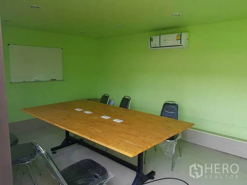 Warehouse for rent in Sai Noi, Nonthaburi - Meeting room with long table, whiteboard and wall-mounted air conditioner.