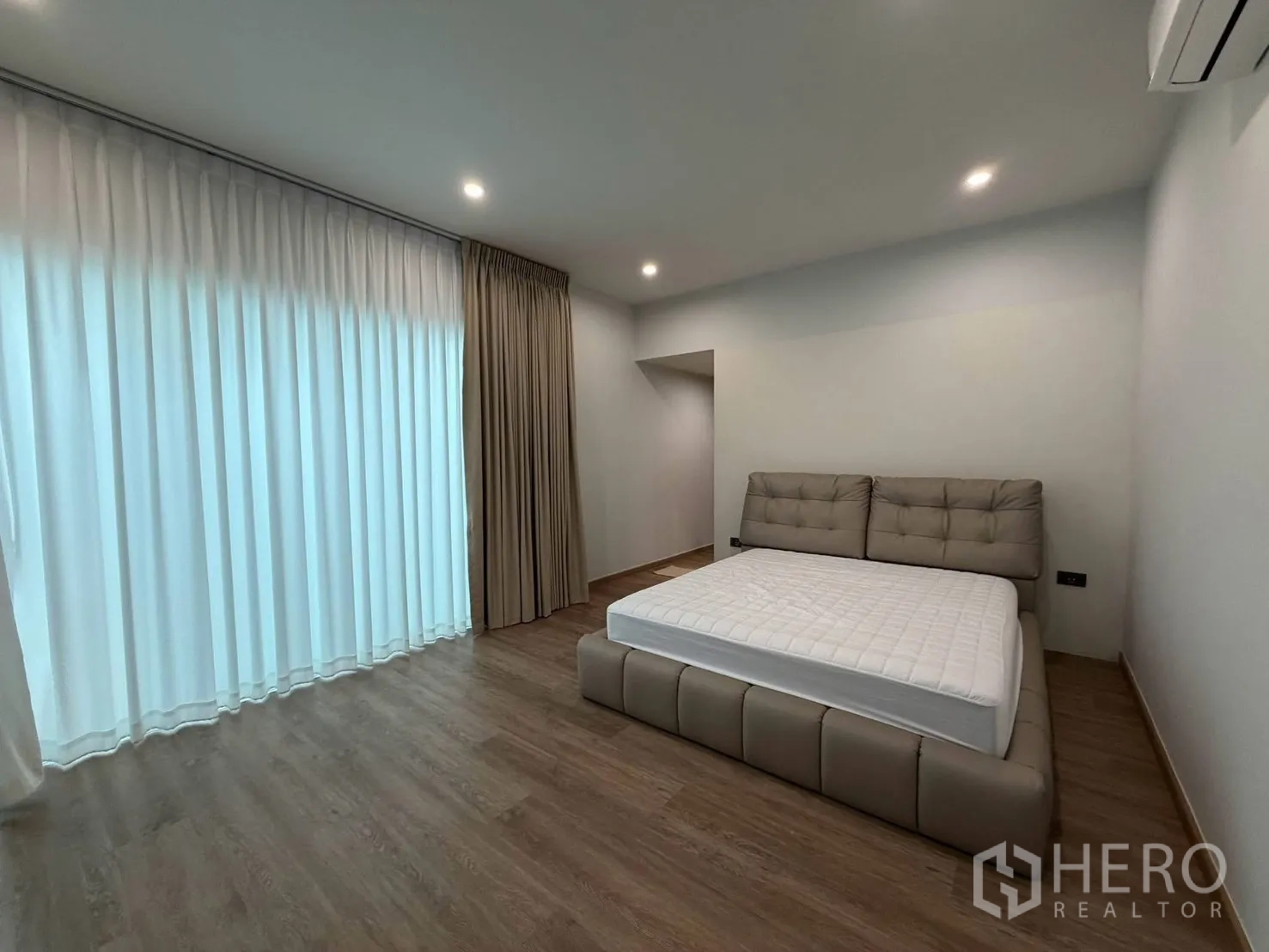 Detached House for rent in Suan Luang, Bangkok - Generous bedroom with large windows, sheer curtains and wood floors.