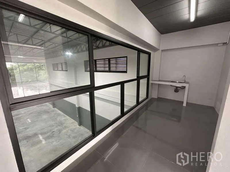 工厂 出租或出售在Bang Bua Thong, Nonthaburi - 办公走廊，内观仓库的玻璃与清洗水槽。