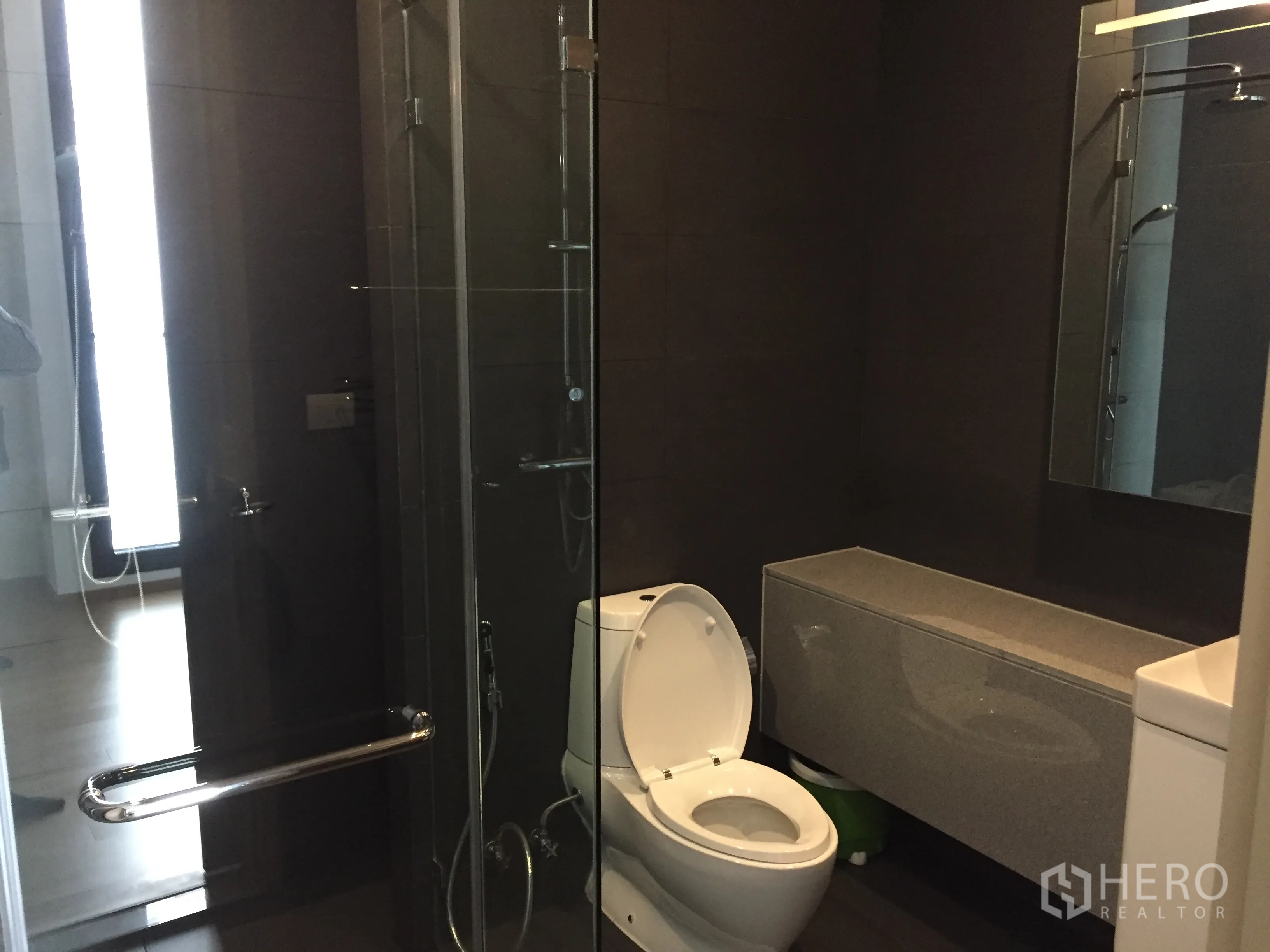 คอนโด ให้เช่าในPathum Wan, Bangkok - ห้องน้ำสไตล์โมเดิร์น มีตู้กระจกอาบน้ำ เคาน์เตอร์ลอย และโถสุขภัณฑ์ โทนกระเบื้องเข้ม