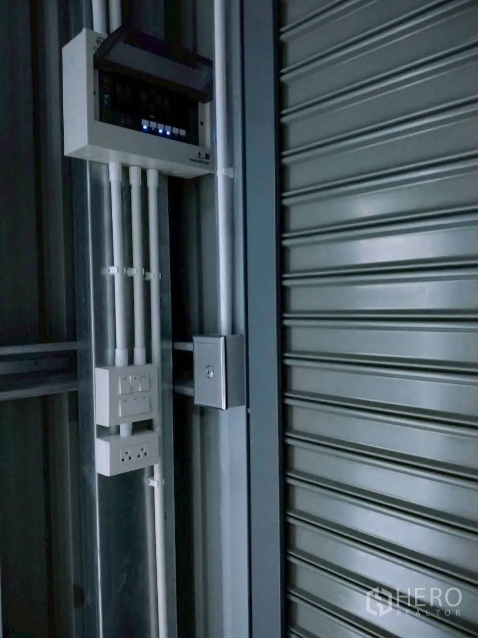 货栈 for rent in Lat Phrao, Bangkok - 卷帘门旁的电气配电箱与多个电源插座特写。