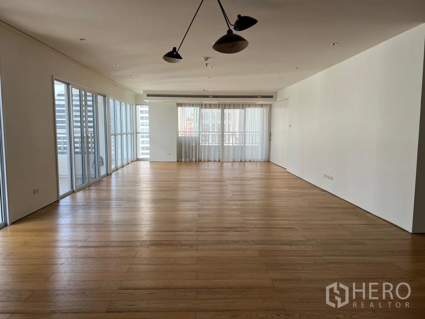 Condominium for rent or sale in Sathon, Bangkok - Expansive living room with multiple sliding doors to balconies and skyline views.