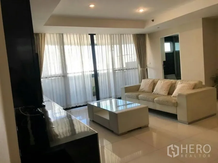 คอนโด ให้เช่าหรือขายในWatthana, Bangkok - มุมนั่งเล่นพร้อมโซฟาและโต๊ะกลางกระจก ข้างผนังหน้าต่างและผ้าม่าน