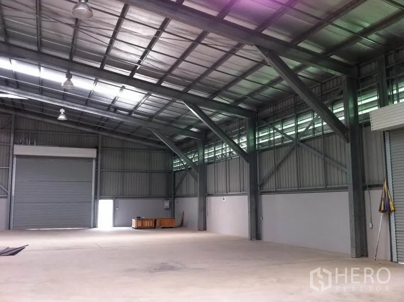 คลังสินค้า ให้เช่าในSai Mai, Bangkok - ภายในโกดังย่านสายไหม กรุงเทพฯ เพดานสูงโครงเหล็ก มีช่องแสง พื้นคอนกรีต และประตูม้วนขนาดใหญ่