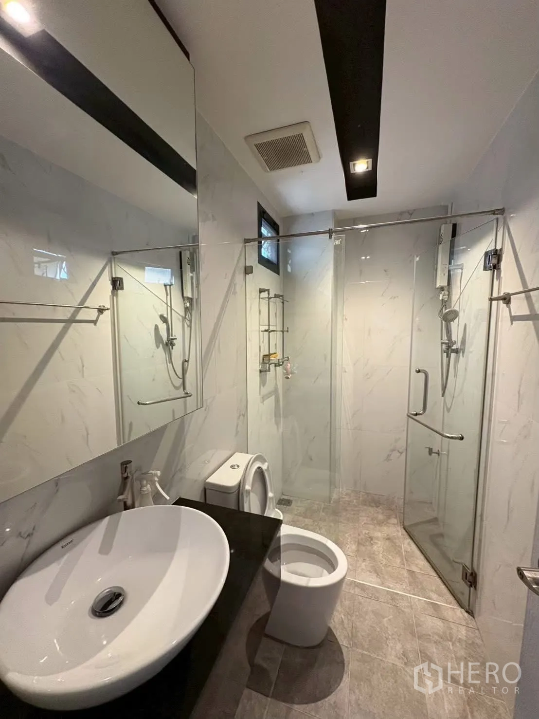 联排别墅 for rent in Pathum Wan, Bangkok - 卫浴配玻璃淋浴间、台上盆与坐便器。