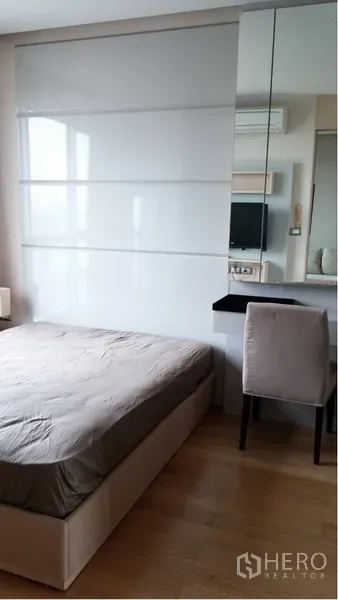 Condominium for rent in Ratchathewi, Bangkok - Cozy bedroom with double bed, glossy sliding wardrobe, mirror, and built-in desk.