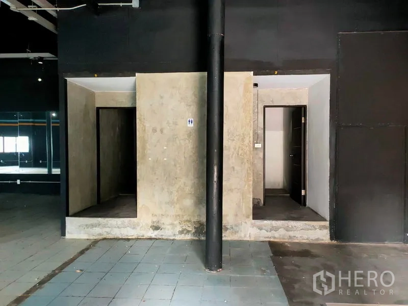 Warehouse for rent in Suan Luang, Bangkok - Built-in restrooms inside the warehouse with concrete partitions and tiled flooring.