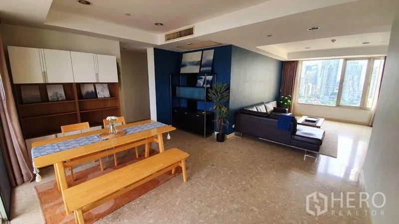 คอนโด ให้เช่าในWatthana, Bangkok - พื้นที่นั่งเล่นและรับประทานอาหารแบบโอเพ่นแปลน โต๊ะไม้ ผนังสีฟ้า และหน้าต่างวิวเมืองบานใหญ่