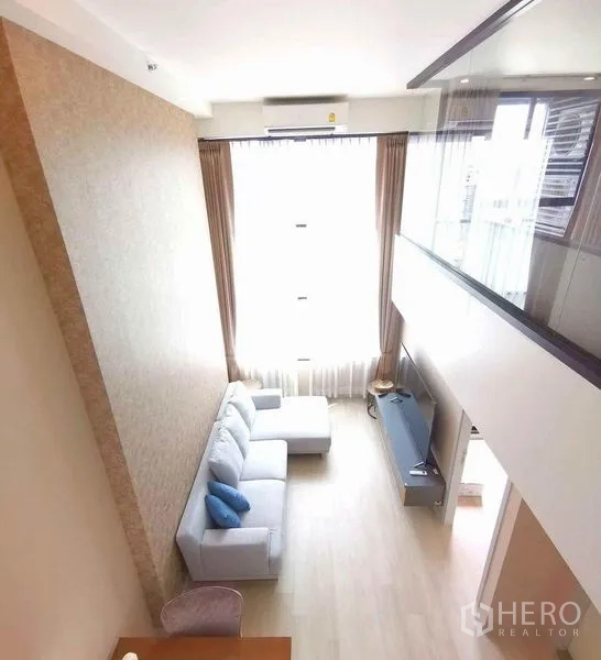 คอนโด ให้เช่าในSathon, Bangkok - ห้องนั่งเล่นสไตล์โลฟต์ เพดานสูงสองชั้น ผ้าม่านสูงเต็มผนัง มุมมองจากชั้นลอย