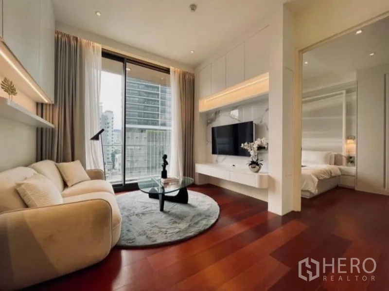 公寓 出租在Watthana, Bangkok - 起居区设壁挂电视与圆形地毯，滑门连接卧室