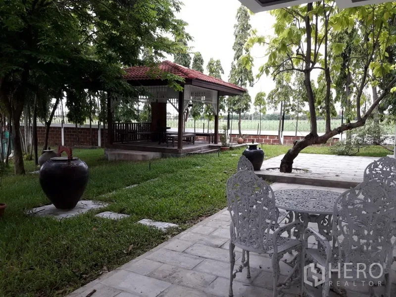 独立式住宅 出租在Bang Na, Bangkok - 花园设遮荫凉亭、草坪与石铺露台餐桌椅