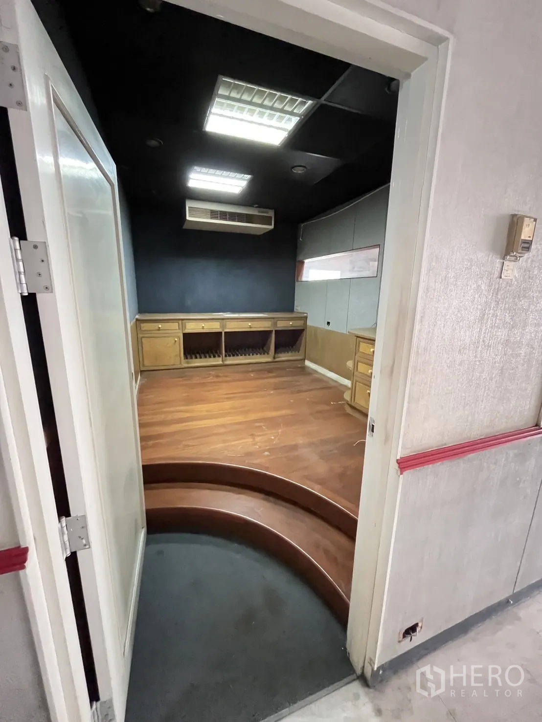 Warehouse for rent in Huai Khwang, Bangkok - Room with raised wooden platform, black ceiling and air conditioning.