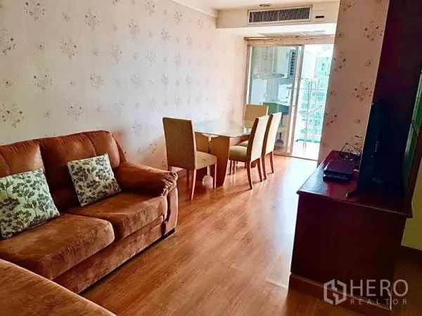 公寓 出租在Khlong Toei, Bangkok - 客厅棕色沙发、电视柜，并可直达阳台。