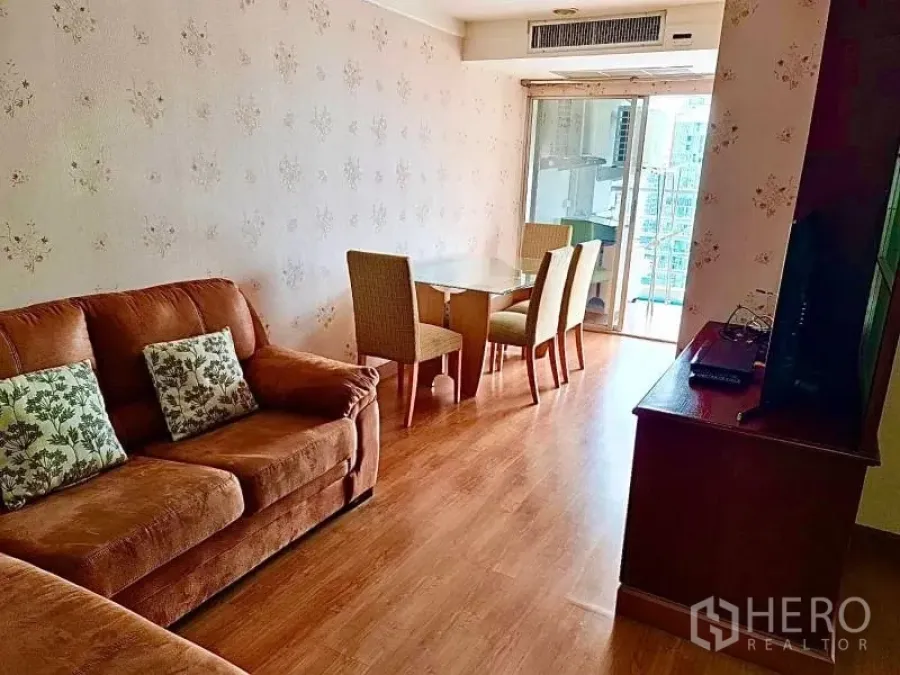 公寓 出租在Khlong Toei, Bangkok - 客厅棕色沙发、电视柜，并可直达阳台。