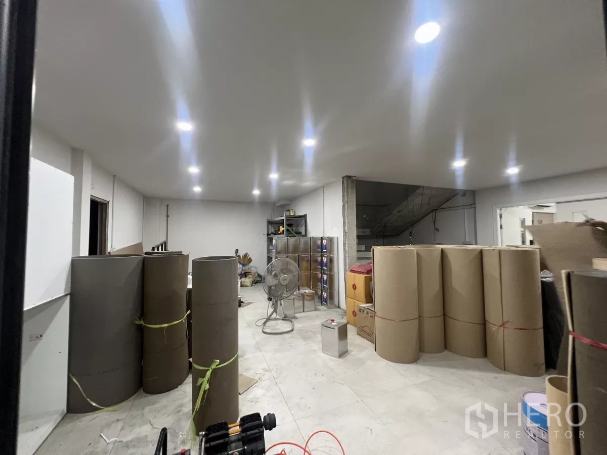 คลังสินค้า ให้เช่าหรือขายในLat Krabang, Bangkok - ห้องชั้นล่างสว่างด้วยไฟดาวน์ไลท์ พร้อมวัสดุและม้วนบรรจุภัณฑ์