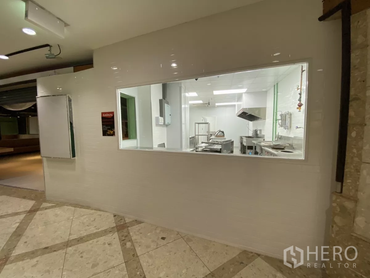 零售空间 出租 - 观景窗后的商业厨房，白色墙砖与不锈钢设备