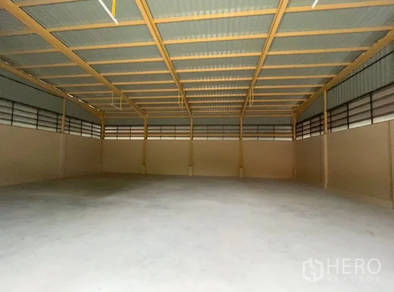 คลังสินค้า ให้เช่าในKhlong Sam Wa, Bangkok - ภายในโกดังโล่งกว้าง โครงหลังคาเหล็กสูง ช่องระบายอากาศ และพื้นคอนกรีตเรียบ