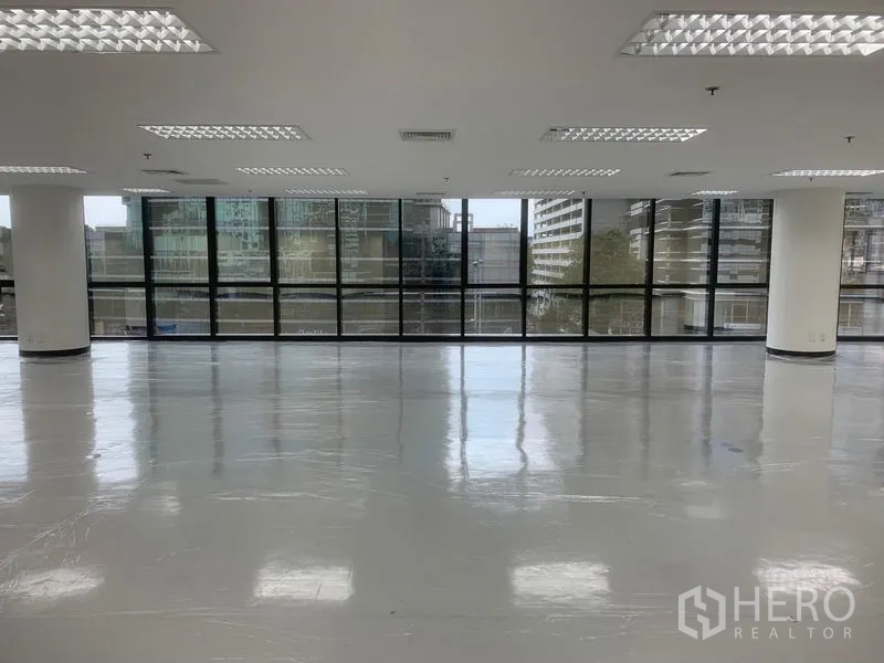 办公空间 出租在Bang Rak, Bangkok - 大面积无柱工作区，整排窗户与网格灯带，可眺望城市景观。