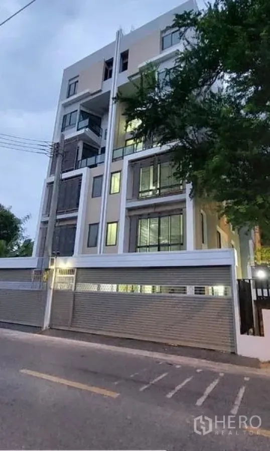 สำนักงานที่บ้าน ให้เช่าในHuai Khwang, Bangkok - ภาพวิวจากถนนของโฮมออฟฟิศร่วมสมัย หน้าต่างเปิดไฟพร้อมกำแพงรอบรั้ว