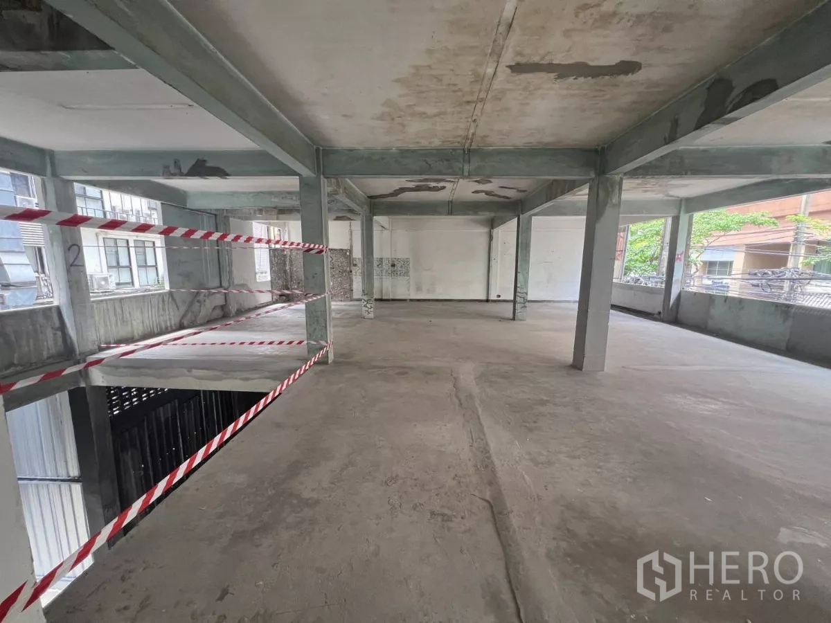 零售空间 出租在Bang Rak, Bangkok - 宽敞规整的毛坯楼板，结构柱与较高层高，两侧带连续窗。